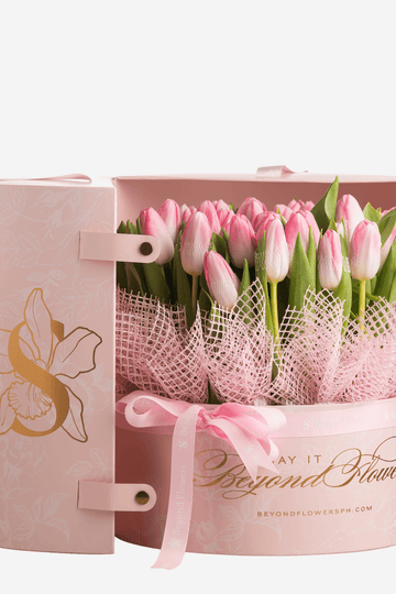 A bouquet of pink tulips in a pink surprise cylinder