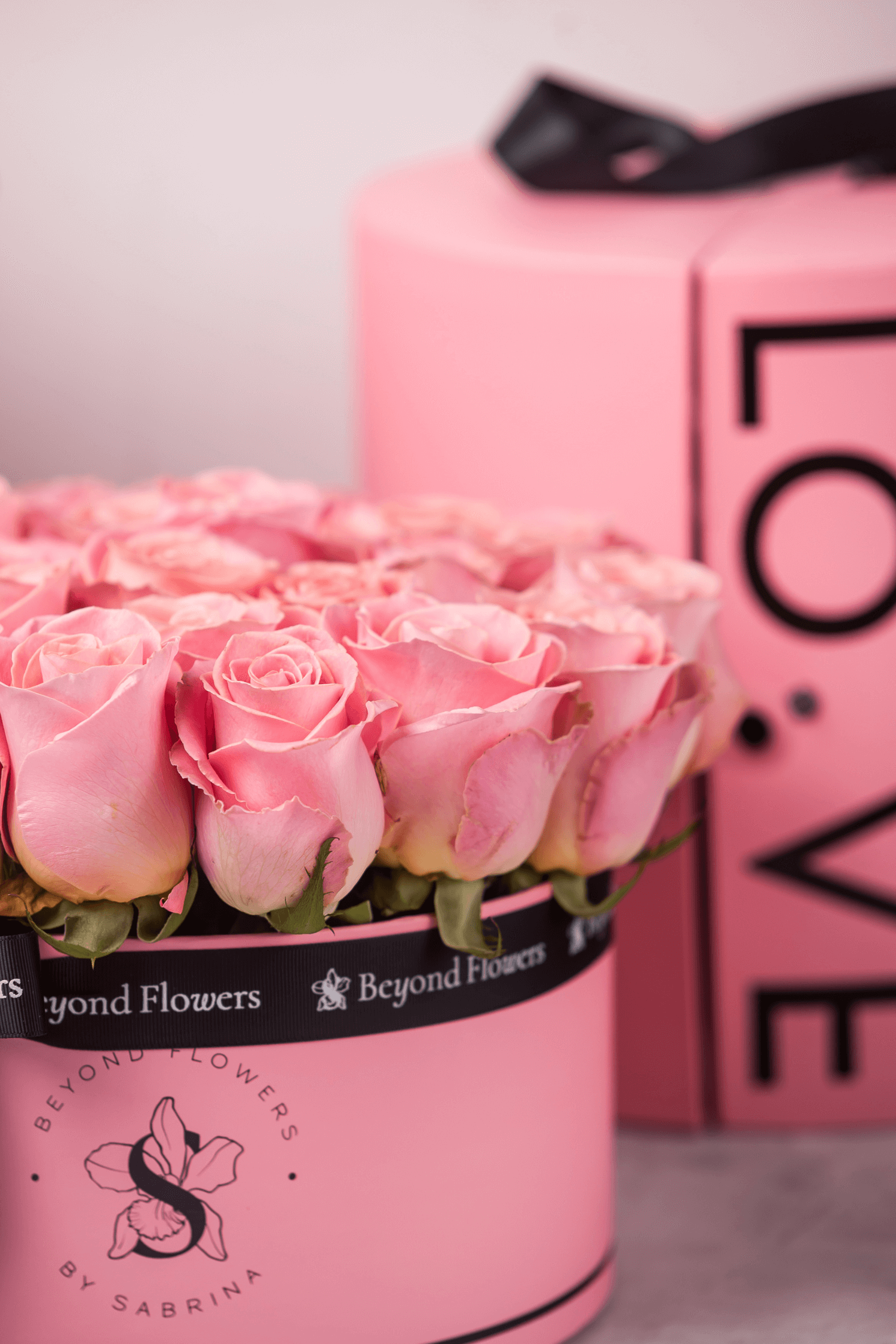 A bouquet of pink Ecuadorian roses arranged in a pink surprise cylinder